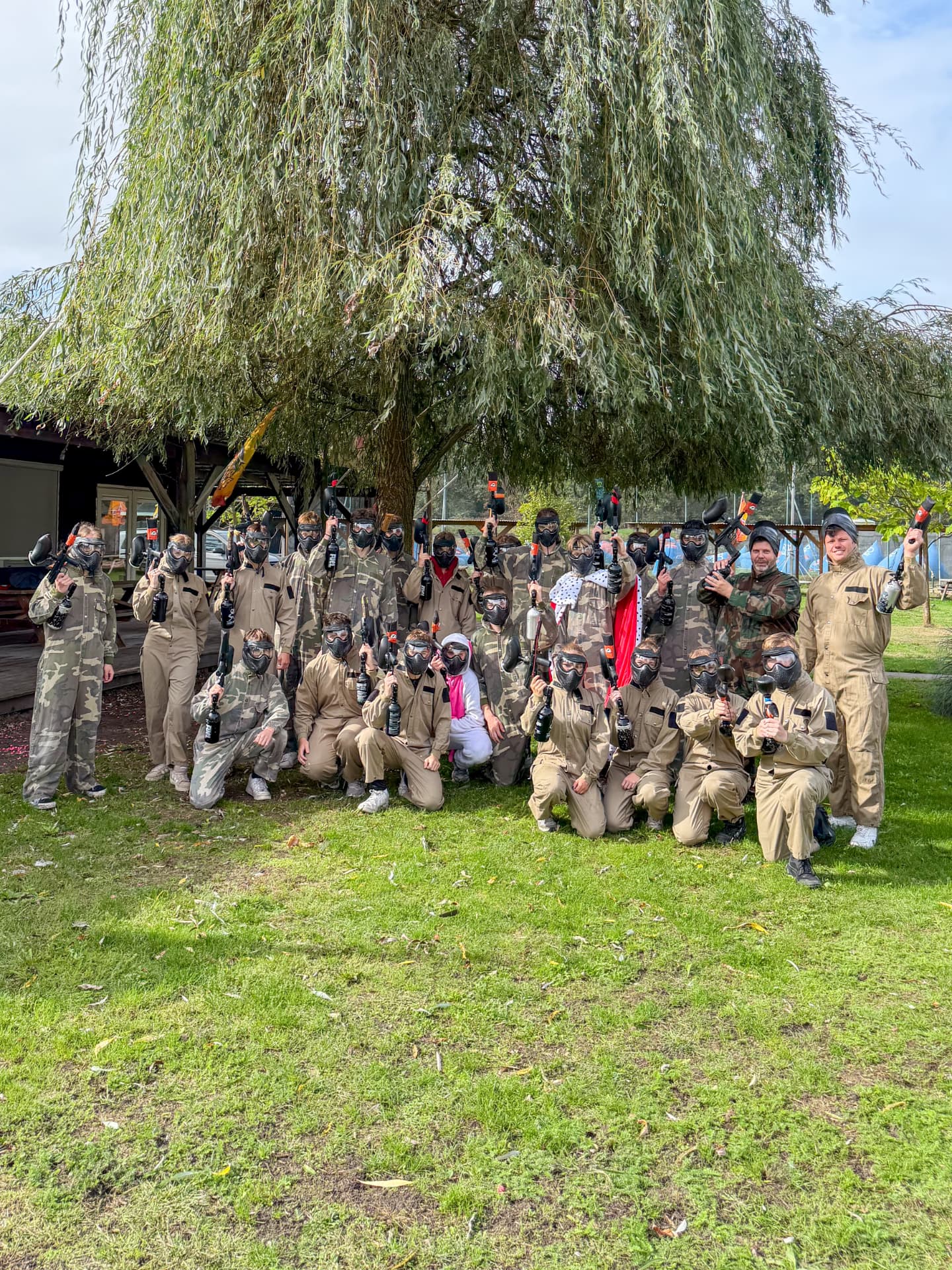 Gruppe von Paintballspielern unter einer großen Weide