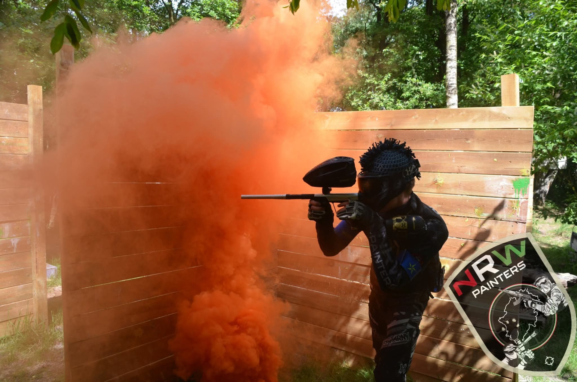 Spieler mit Marker neben orangefarbenem Rauch beim Woodland